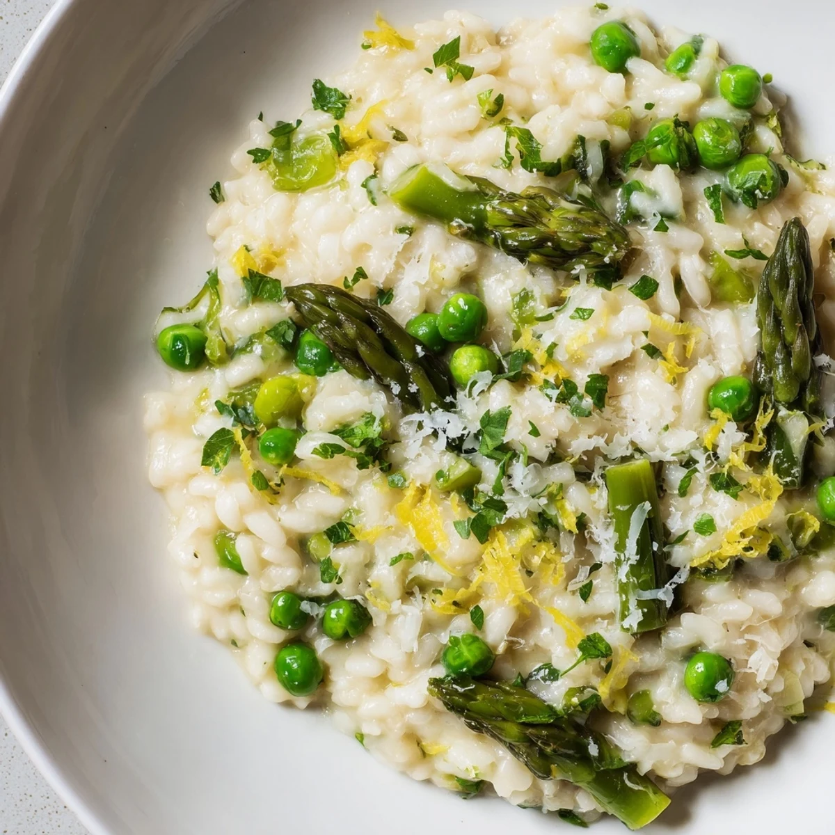 Bright green spring peas and crisp asparagus spears nestled in creamy Spring Pea and Asparagus Risotto, garnished with fresh parsley.