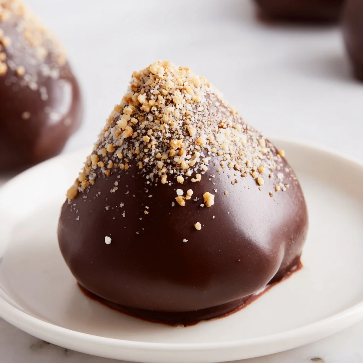 A platter of Chocolate Covered Marshmallow Peeps arranged on parchment, some with crushed nuts and sea salt garnish.