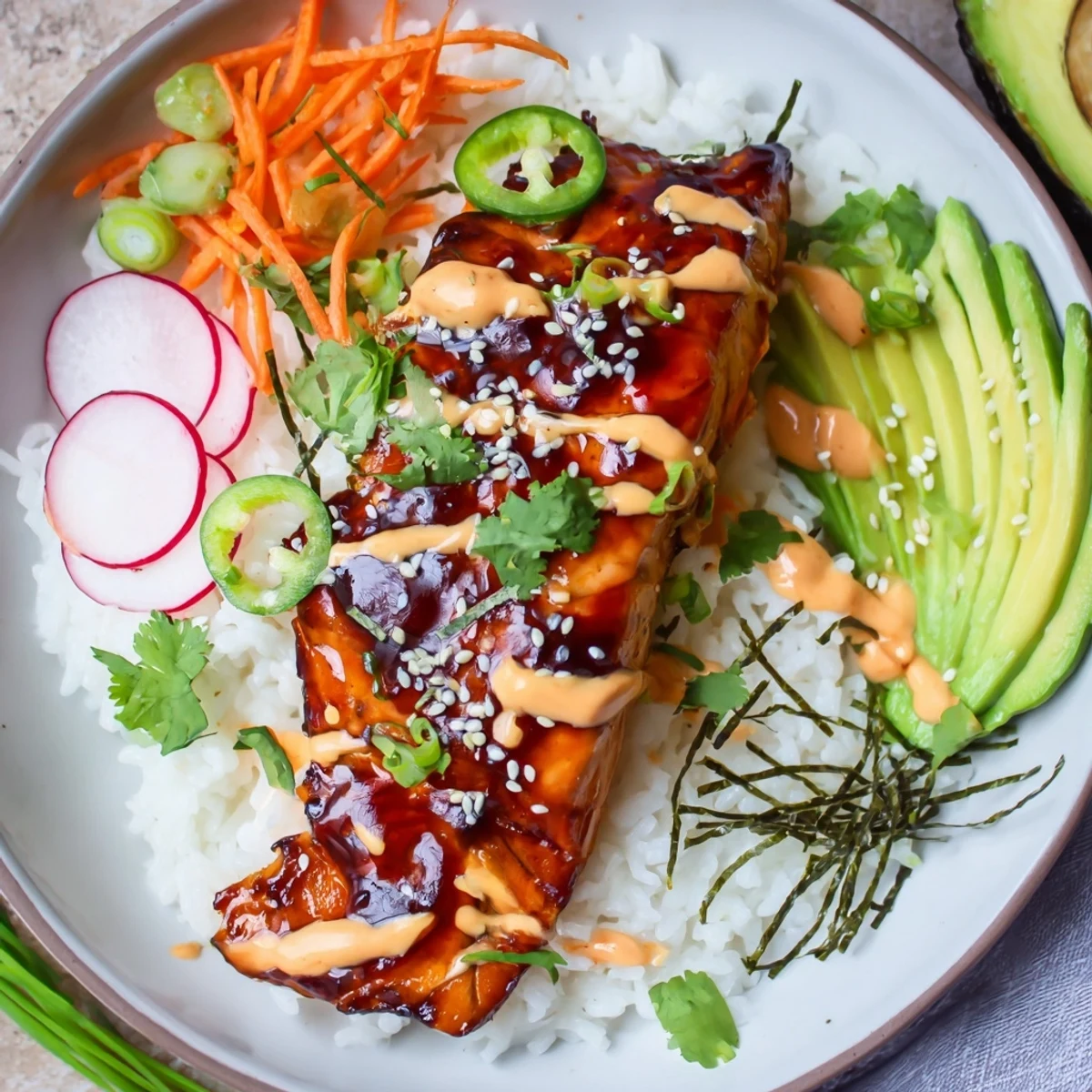 A bowl filled with flaky salmon, fluffy rice, creamy avocado, and colorful pickled veggies, all drizzled with teriyaki and sriracha mayo—these Teriyaki Salmon Rice Taco Bowls with Pickled Veggies look delicious.