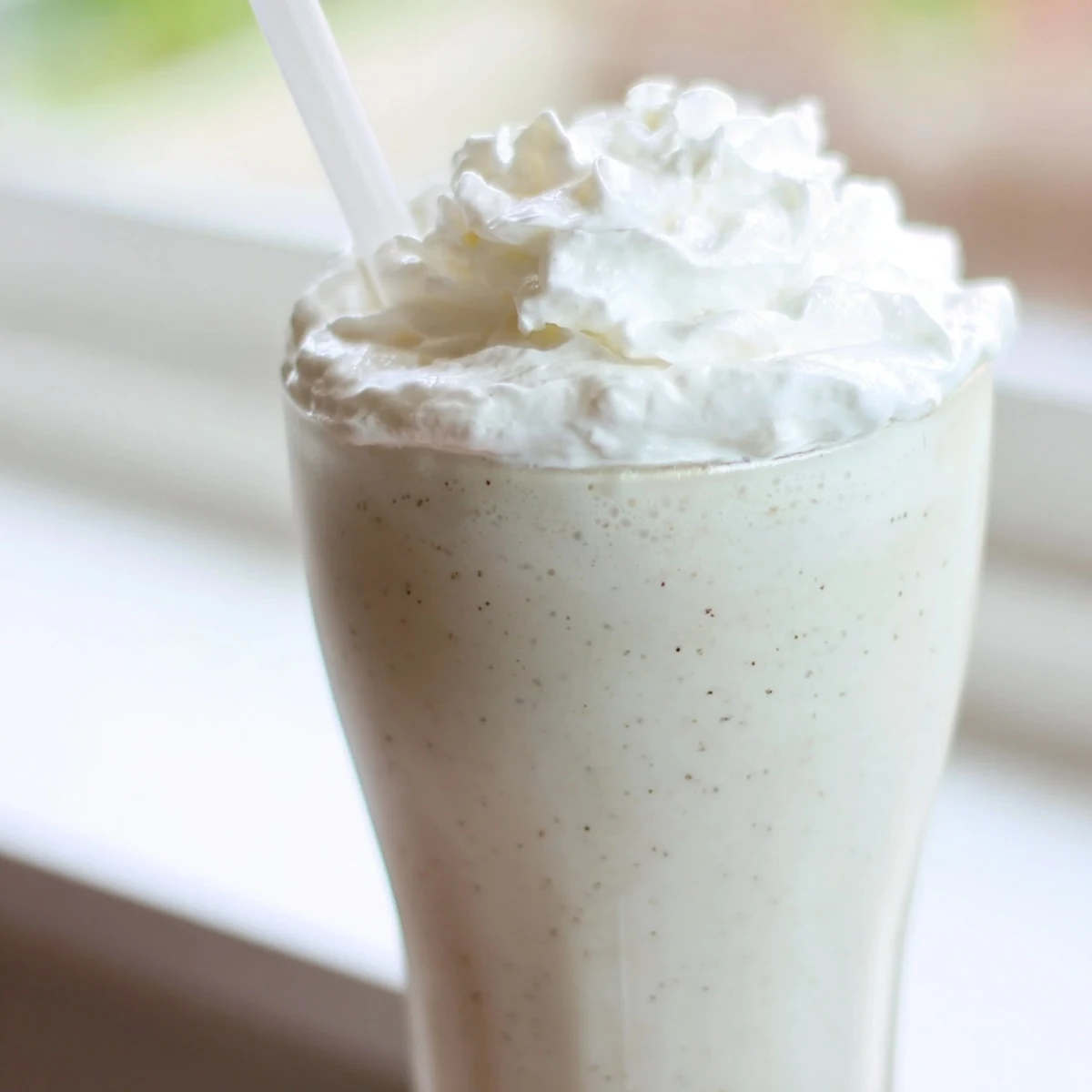 Creamy Starbucks Vanilla Bean Frappuccino topped with whipped cream served in a tall glass.