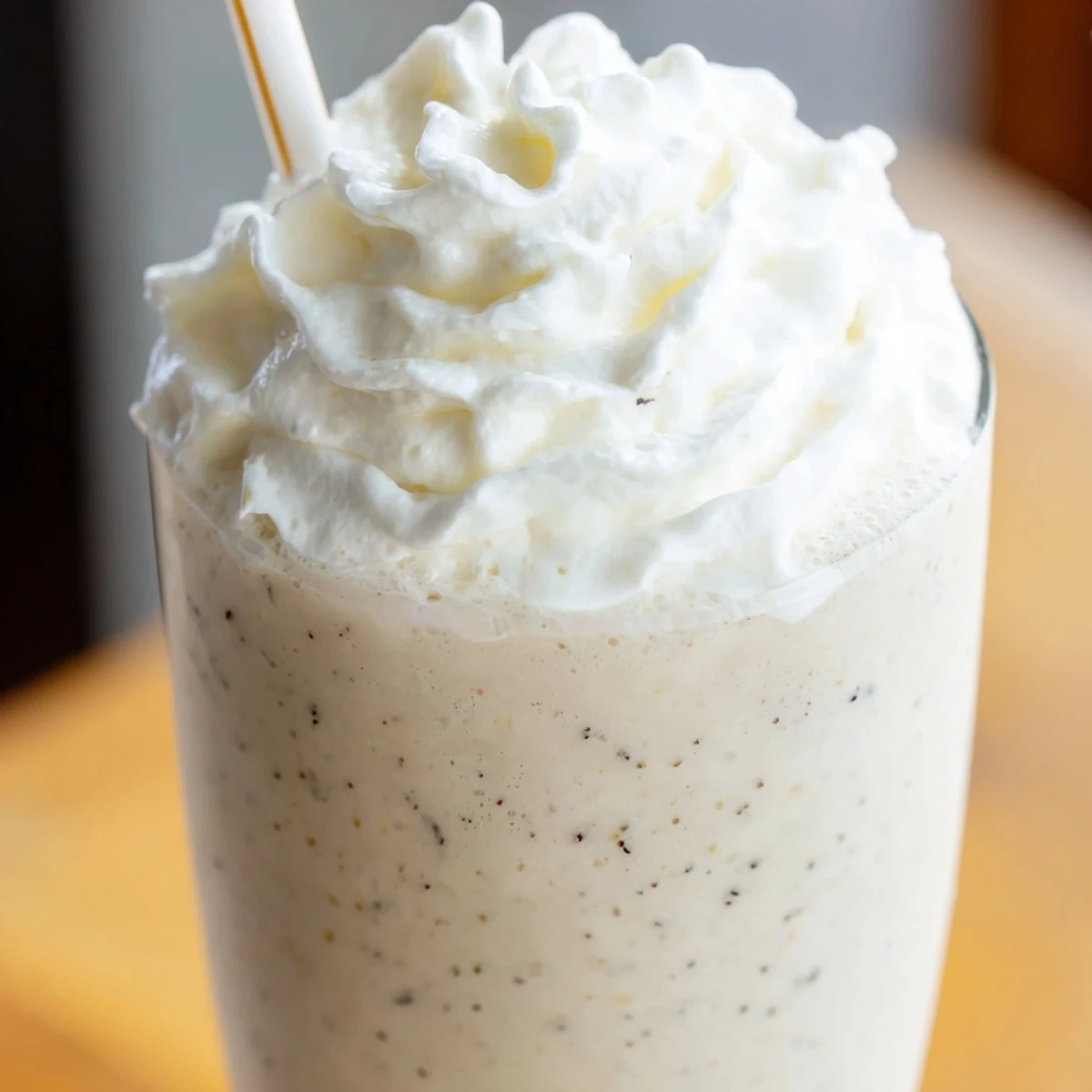 Homemade Starbucks Vanilla Bean Frappuccino in a frosted glass with a straw and sweet vanilla aroma.