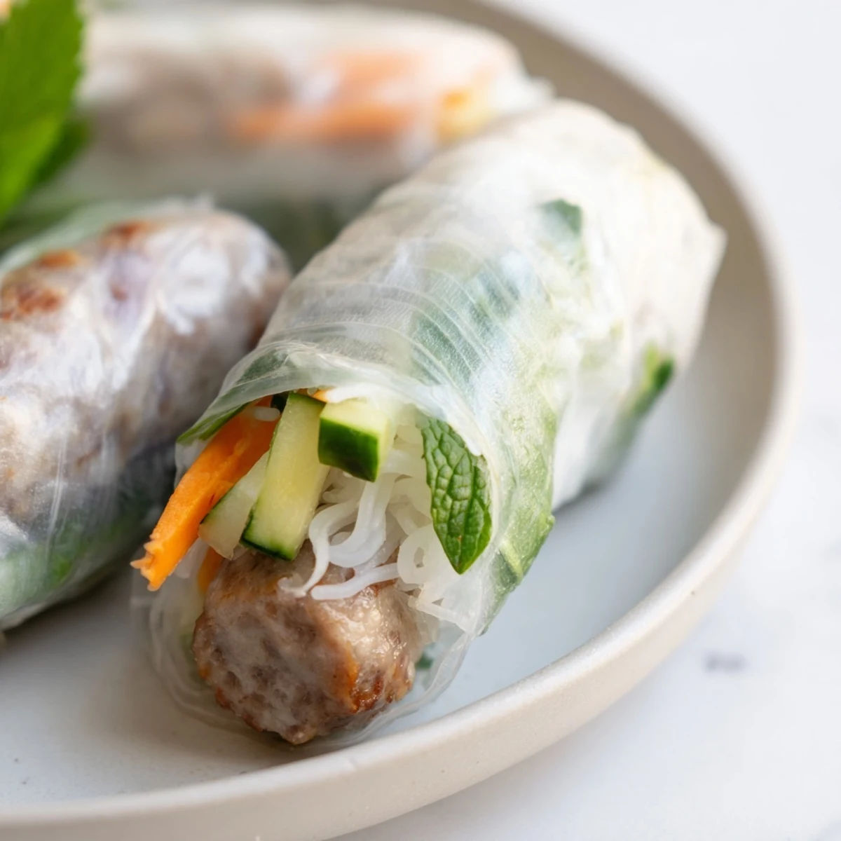 Succulent Nem Nuong spring rolls with grilled pork sausage, fresh herbs, and crisp veggies, served with nuoc cham dipping sauce.