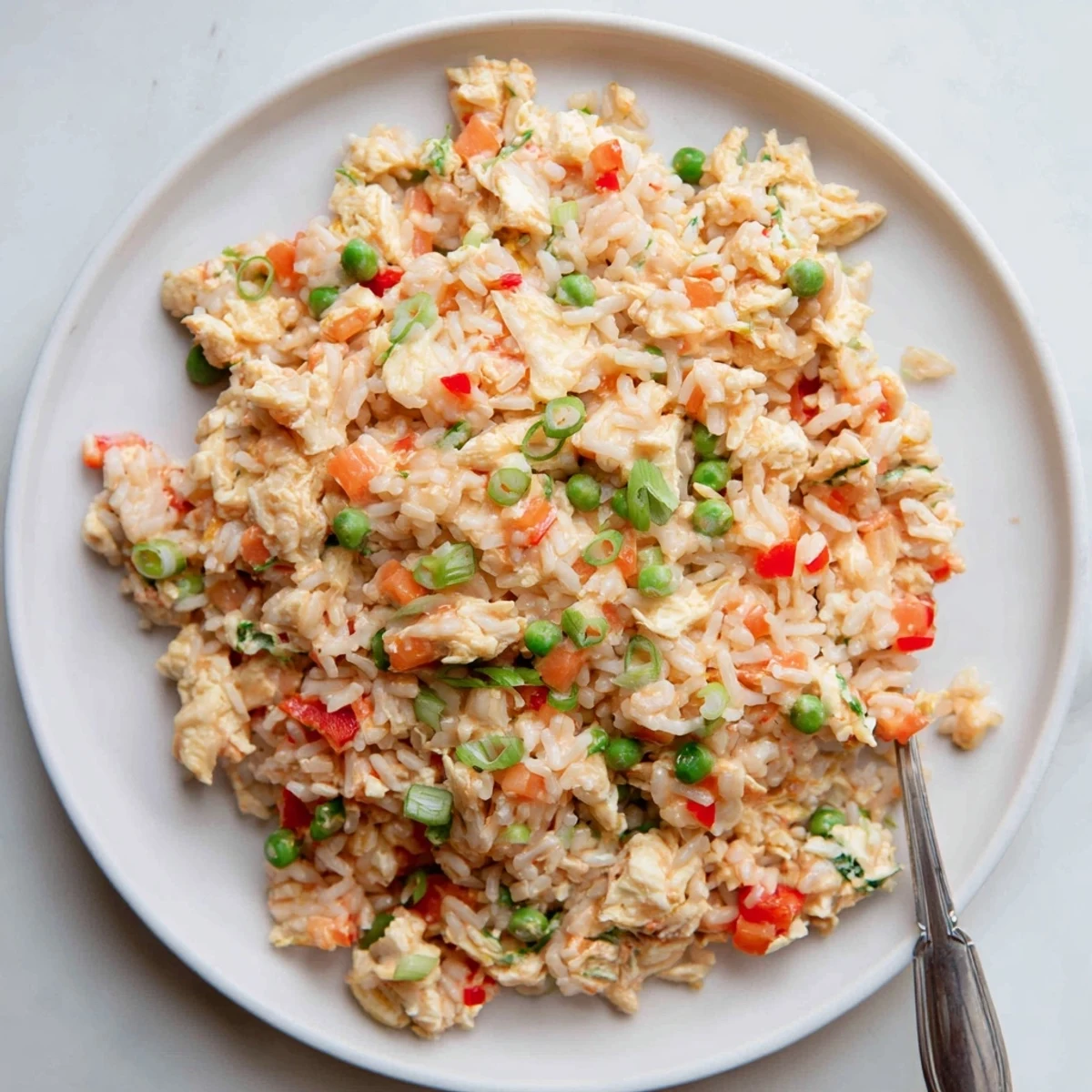 Scrambled eggs and peas mixed into vibrant Bang Bang Fried rice in a hot wok.