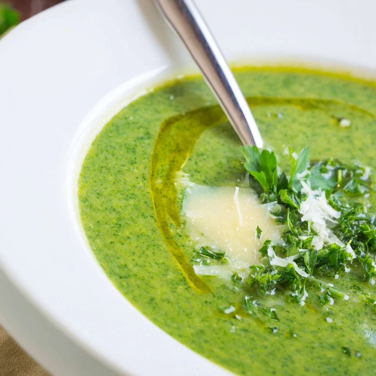 Steaming bowl of homemade Italian broccoli soup with crusty bread, drizzled with olive oil and parsley