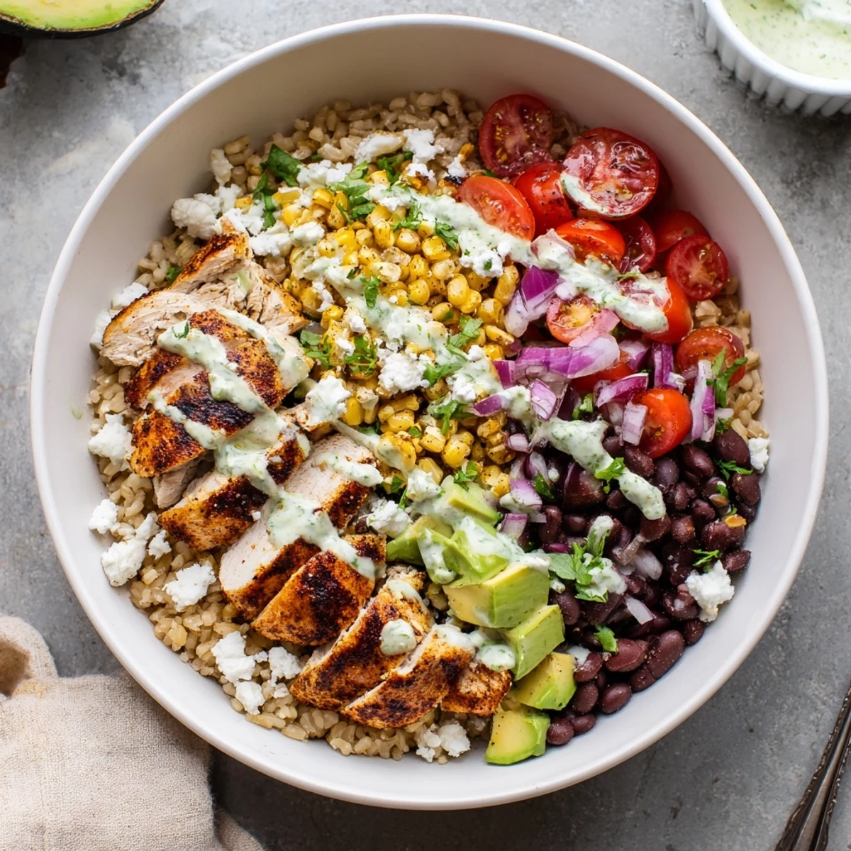 Vibrant protein packed street corn chicken bowl with grilled chicken, charred corn, black beans, avocado, and zesty yogurt-lime drizzle over fluffy rice.