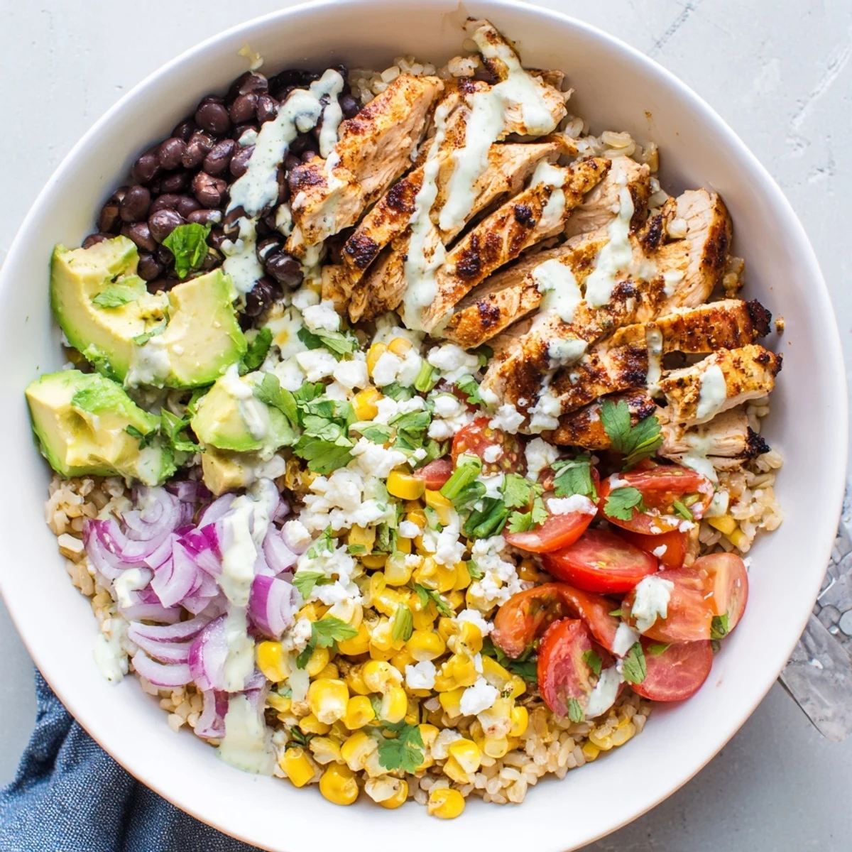 Hearty protein packed street corn chicken bowl layered with juicy chicken, black beans, cherry tomatoes, avocado, and tangy yogurt-lime sauce.