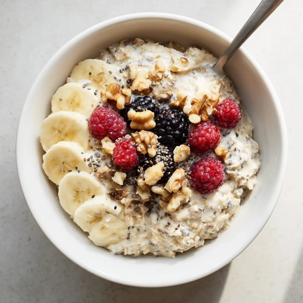 Creamy brown sugar overnight oats in a glass jar topped with fresh berries and chopped nuts