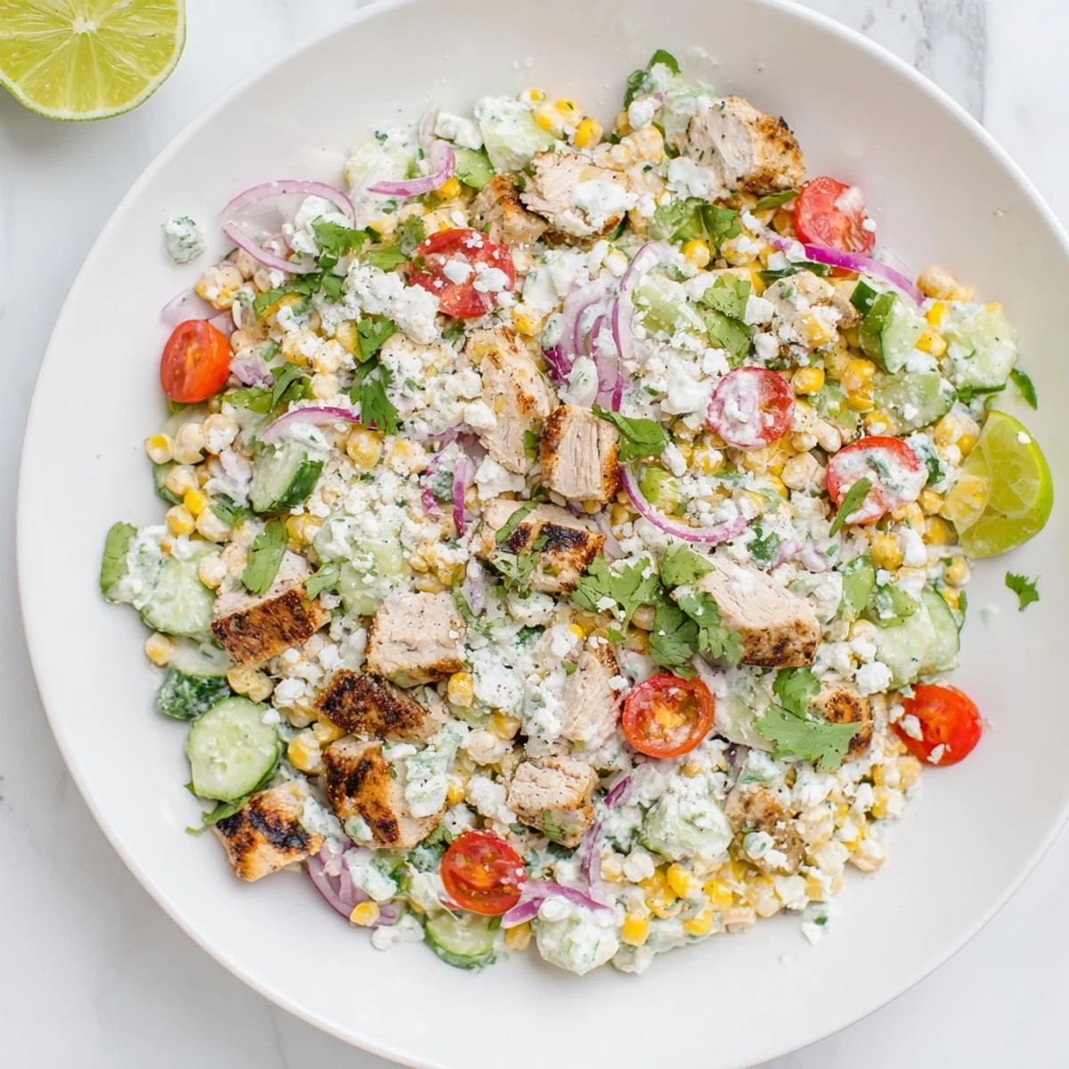 Colorful street corn creamy cucumber chicken salad with grilled chicken chunks, sweet charred corn kernels, crisp diced cucumbers, cherry tomatoes, and red onion tossed in zesty lime-spiced dressing
