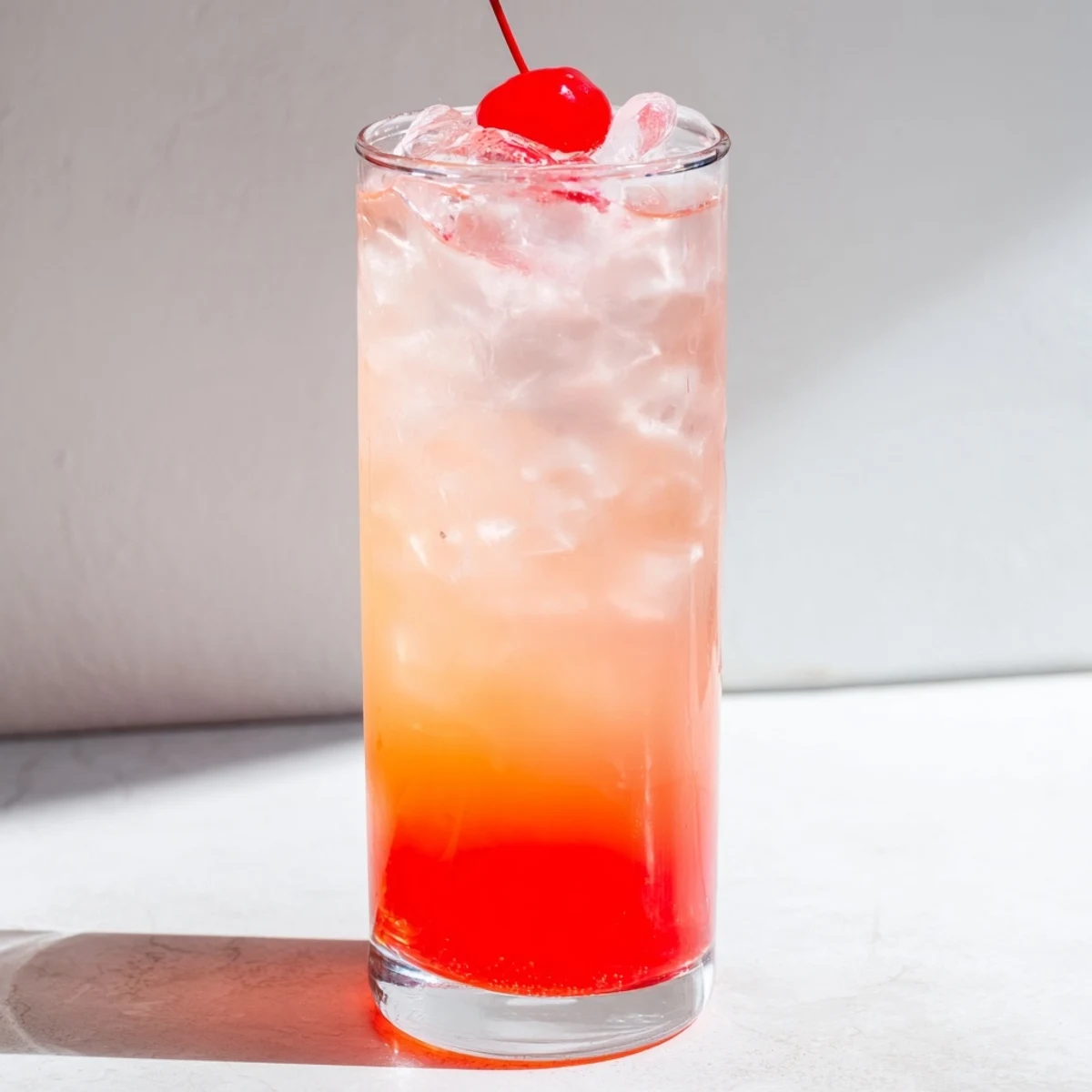 Classic Shirley Temple beverage with ice, lemon-lime soda, and cherry garnish on serving tray