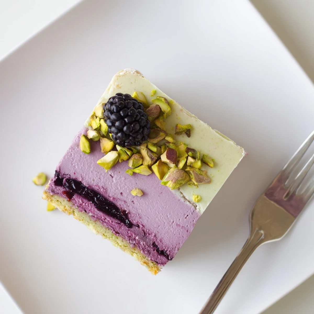Creamy cheesecake layer swirled with tangy blackberry compote over green pistachio shortbread crust
