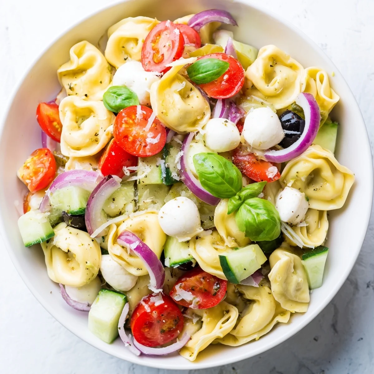 Colorful tortellini salad tossed with crisp vegetables and mozzarella in zesty Italian dressing