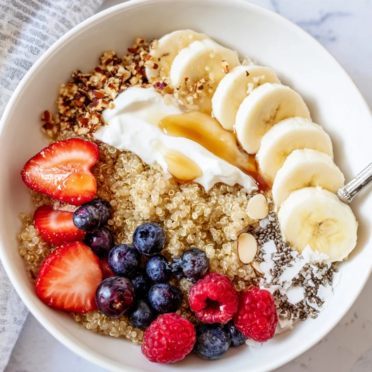 Warm Quinoa Breakfast Bowl steaming beside sliced banana and honey drizzle.