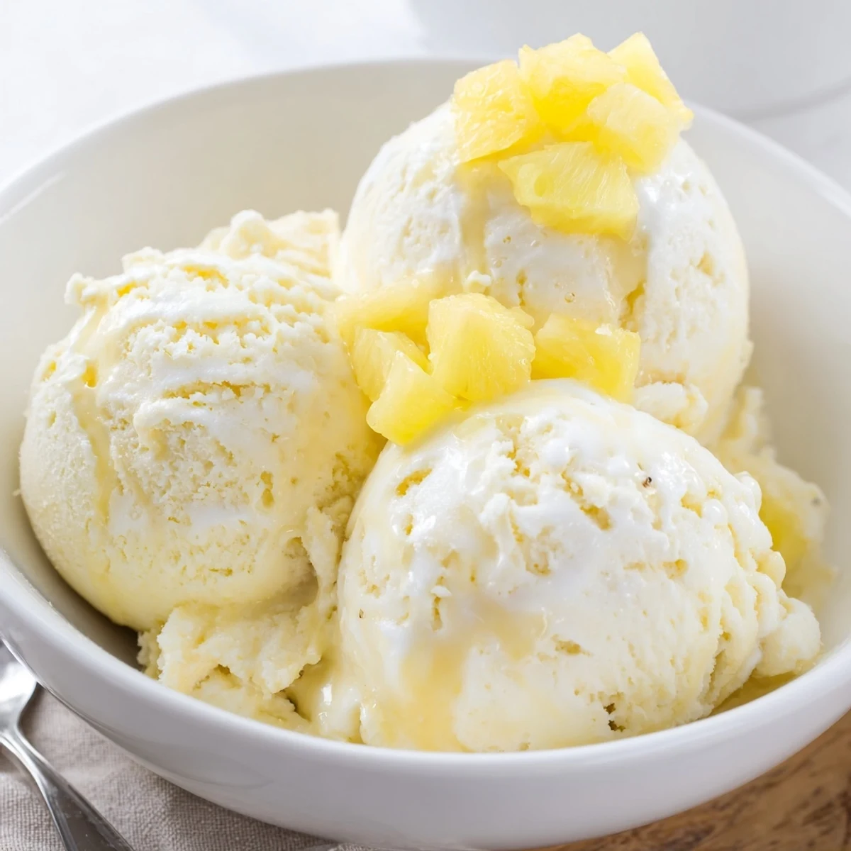 Creamy Pineapple Ice Cream Recipe on bowl, golden flecks and velvety texture