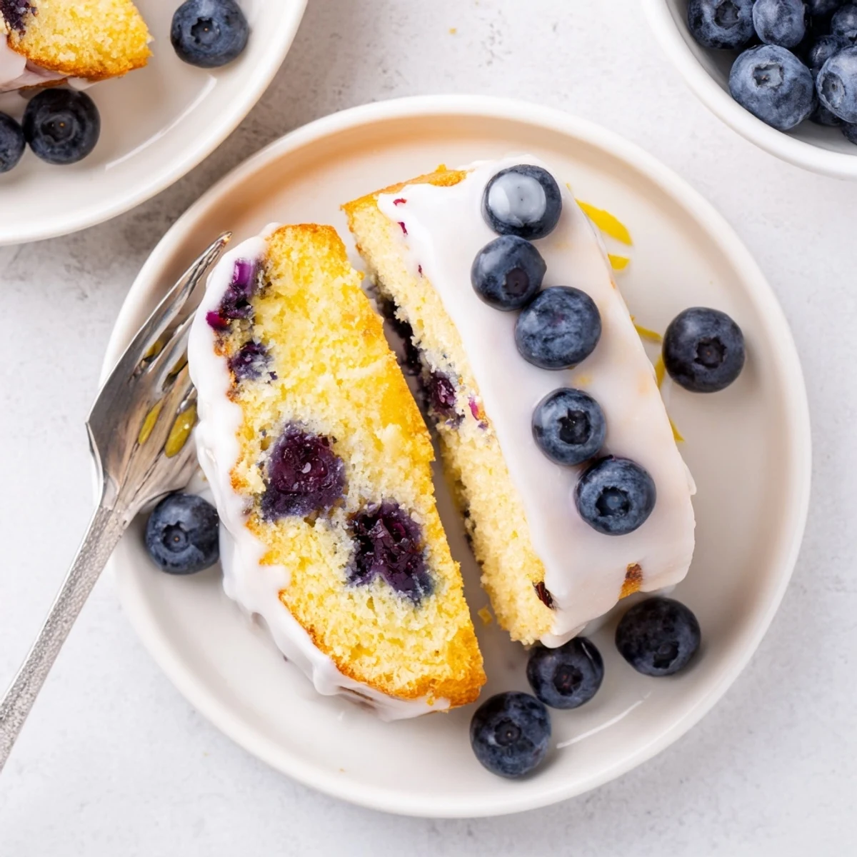 Bundt of lemon blueberry cake topped with sweet icing and whole blueberries