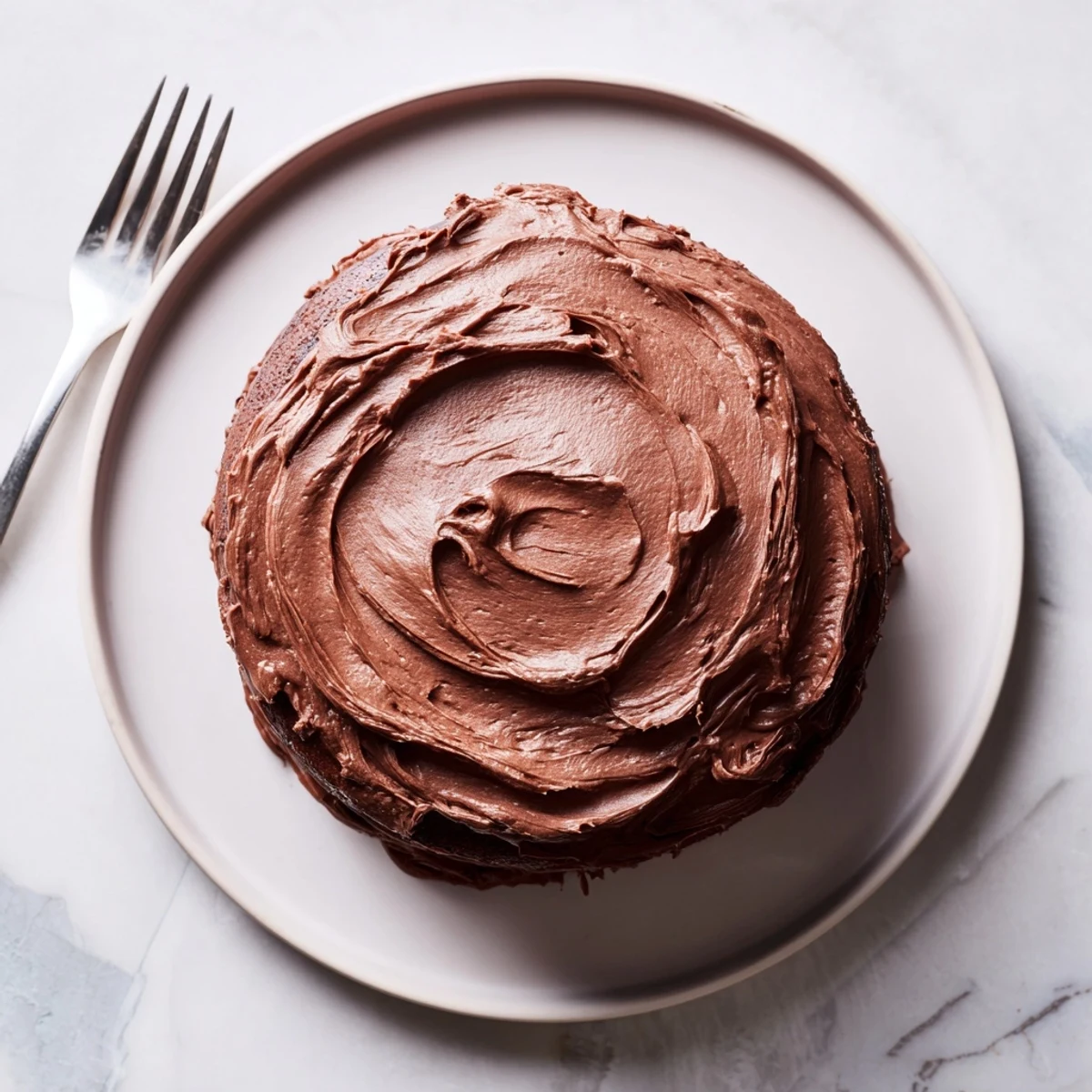 Decadent Matilda chocolate cake with moist layers and rich chocolate frosting swirled on top.