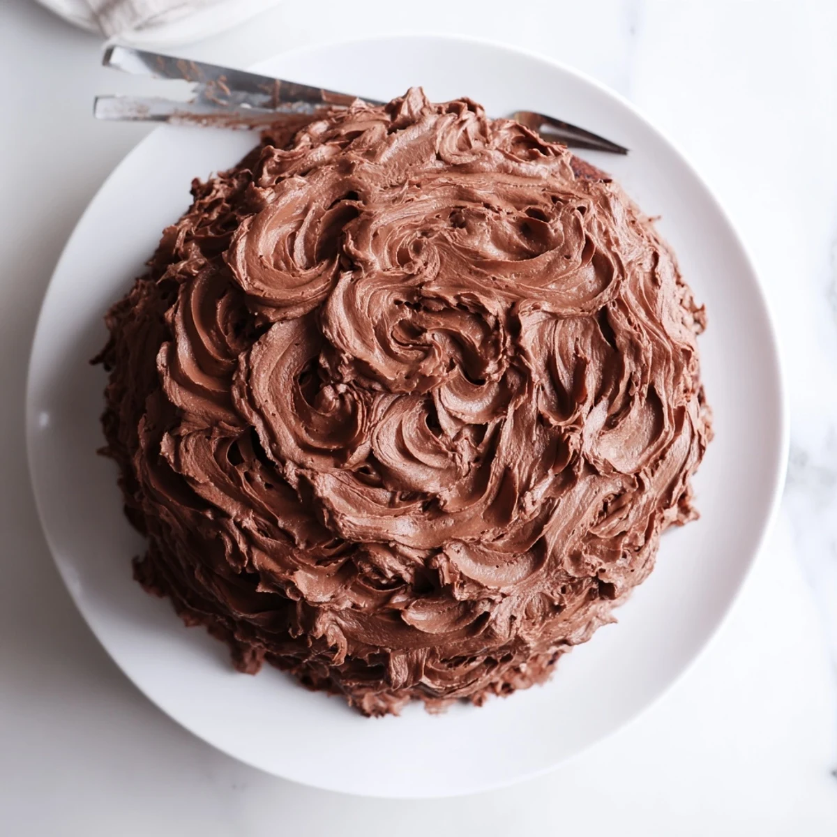 Two-layer Matilda chocolate cake covered in smooth cocoa frosting with dramatic swoops and swirls.