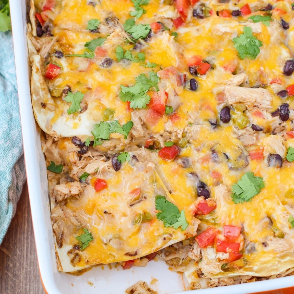 Family style creamy chicken taco lasagna garnished with fresh cilantro on a serving platter