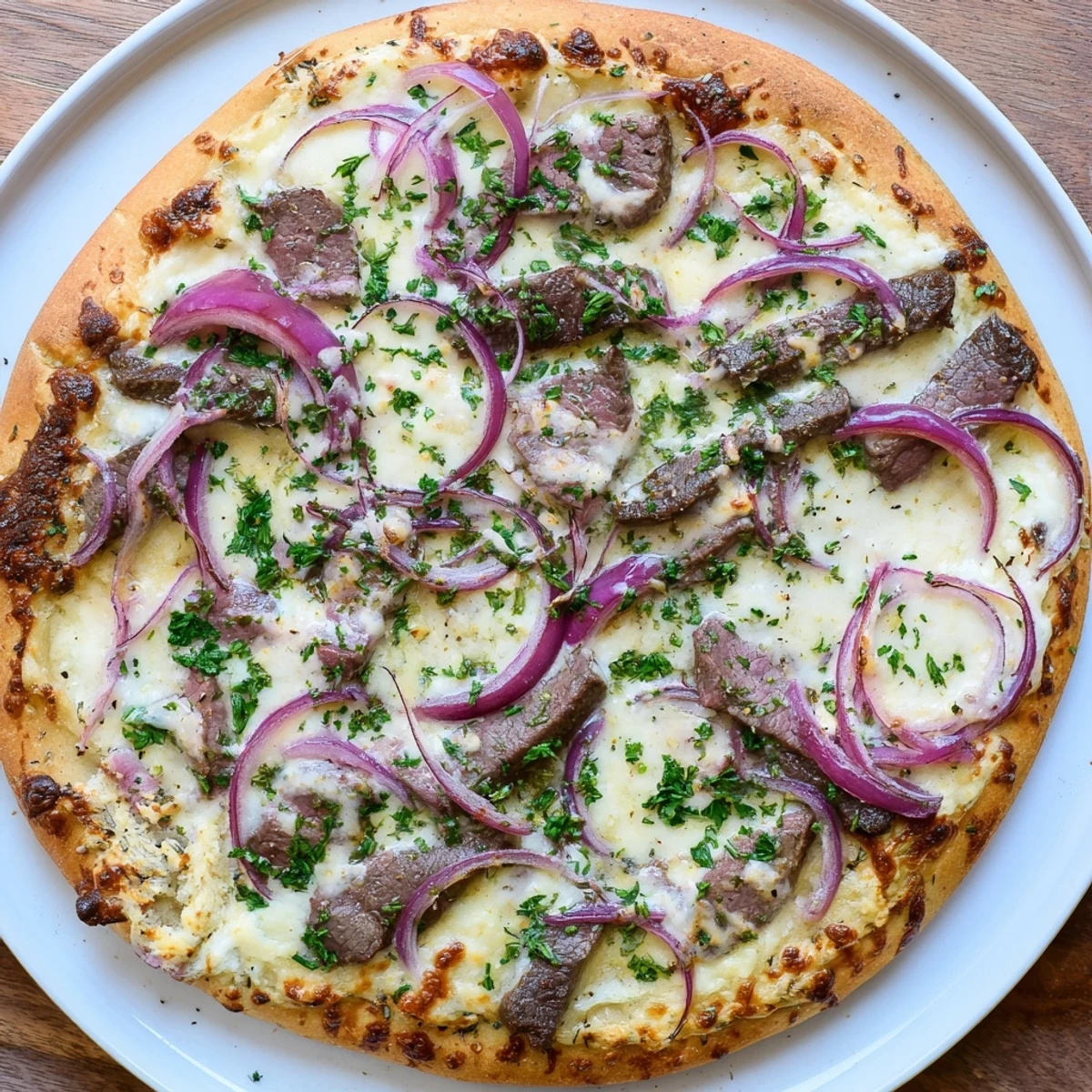 Golden Beef Alfredo Pizza with bubbling mozzarella, tender sliced steak, and fresh parsley garnish