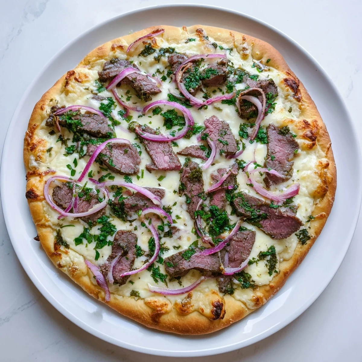 Savory American-Italian fusion pizza featuring creamy garlic Alfredo sauce, melted cheeses, and seared beef slices