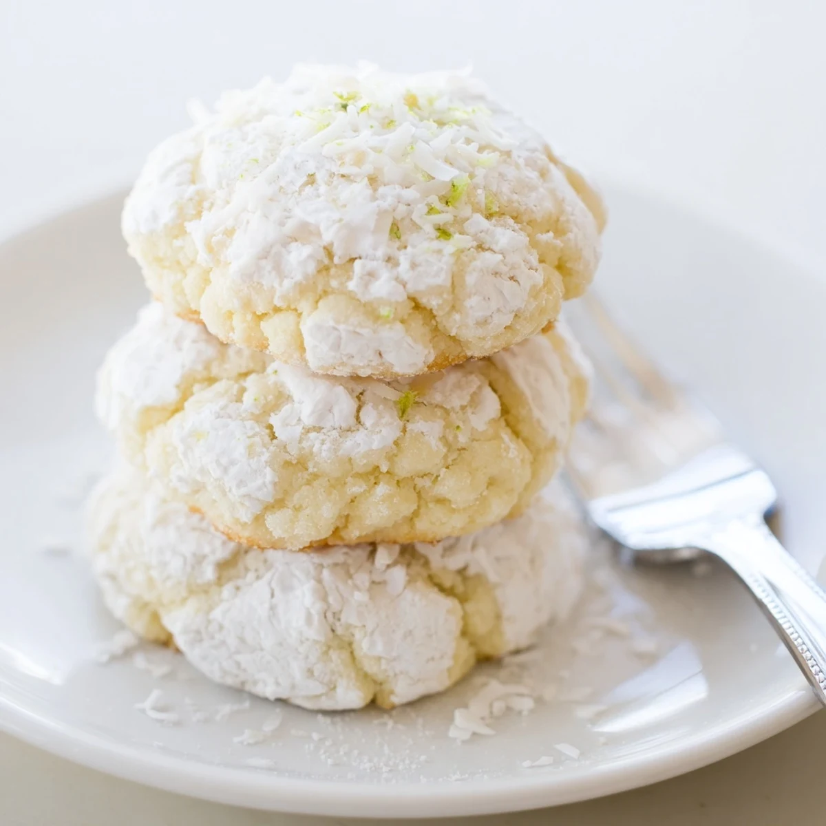 Stacked Tropical Coconut Key Lime Crinkle Cookies on wire rack, served with iced tea