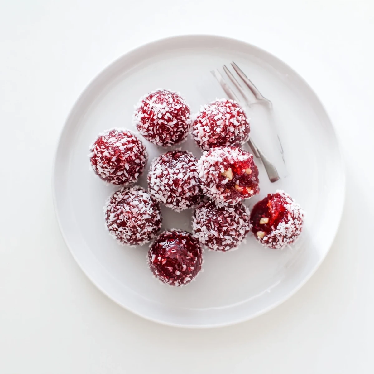 Homemade Christmas Jello Balls chilled on parchment, tangy pineapple and soft texture
