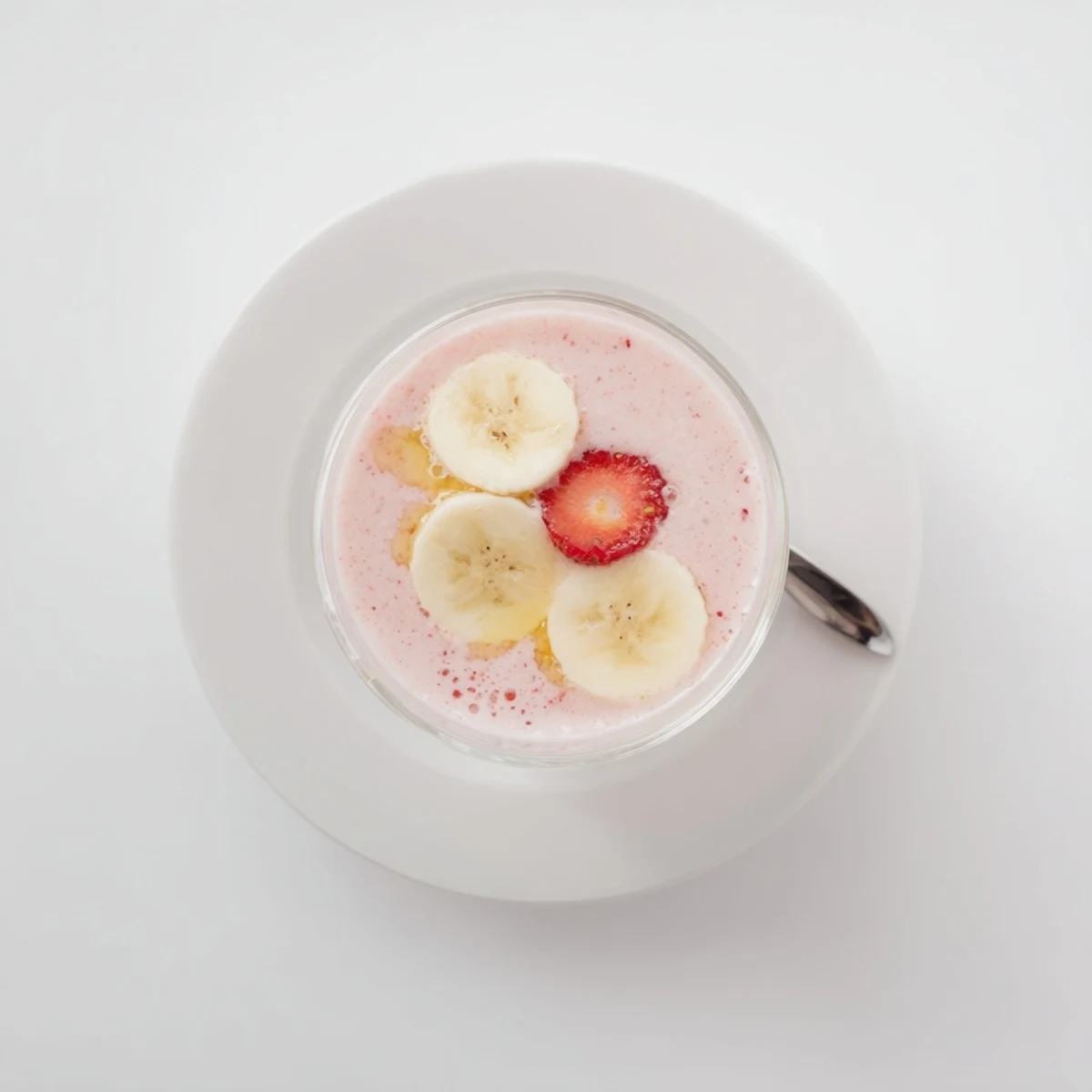 Creamy chilled glass of pink fruit blend, Strawberry Banana Smoothie Recipe for breakfast.