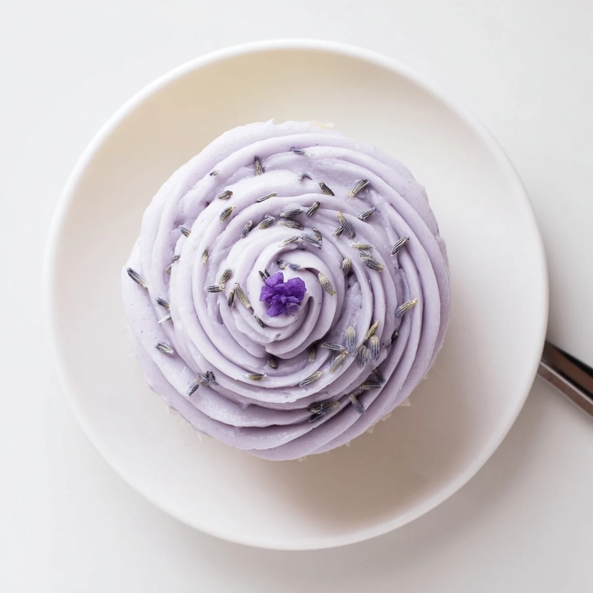 Lavender Buttercream Floral Frosting piped into swirls atop vanilla cupcakes.