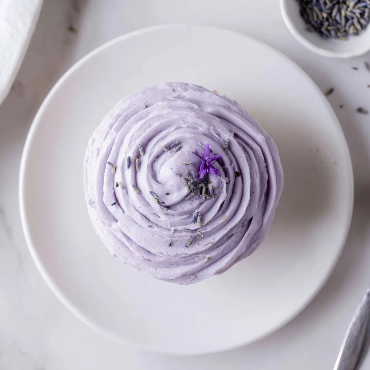 Soft, aromatic Lavender Buttercream Floral Frosting spread on lemon cake slices.