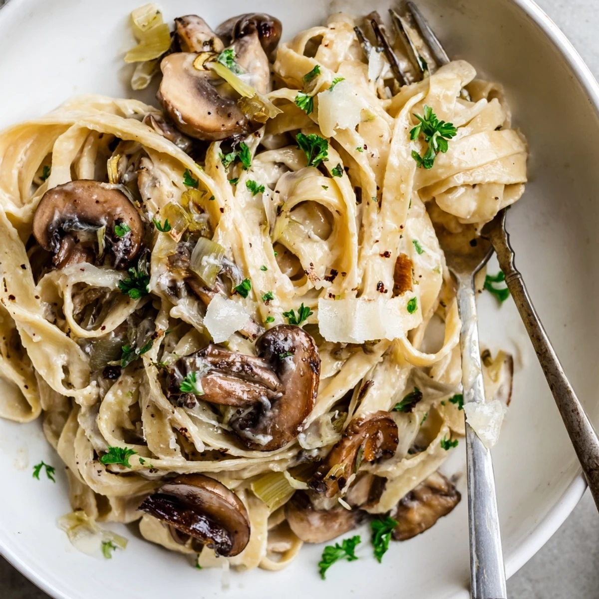 Creamy Caramelized Leek Mushroom Gruyere Pasta twirled on fork, nutty cheese melting
