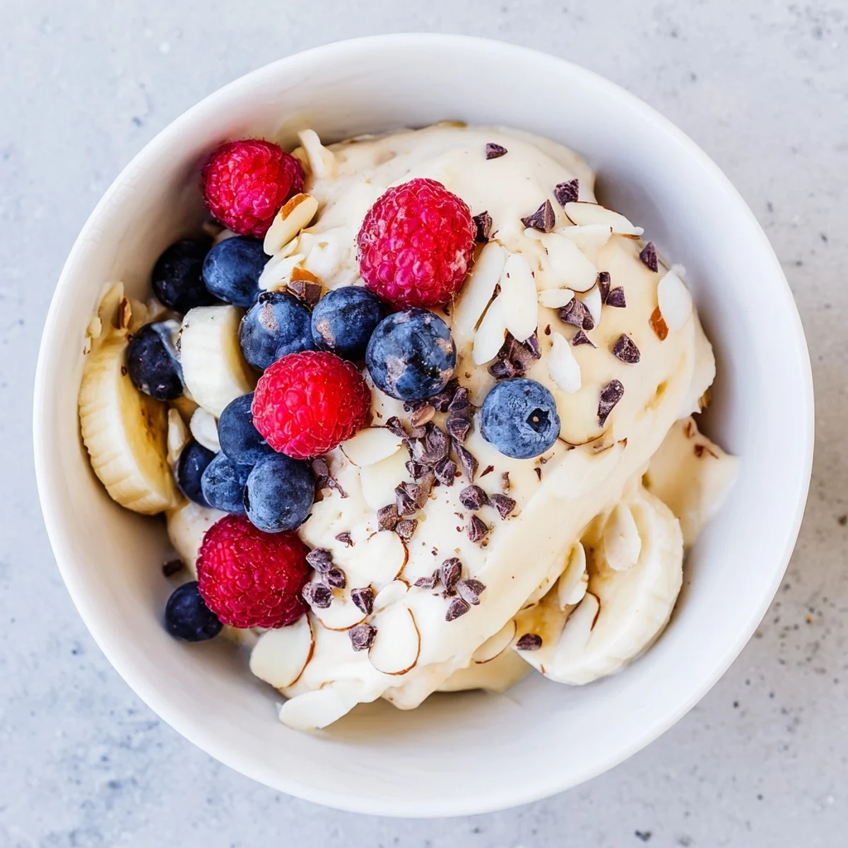Smooth dairy-free banana nice cream swirling in a glass with a spoon ready to enjoy