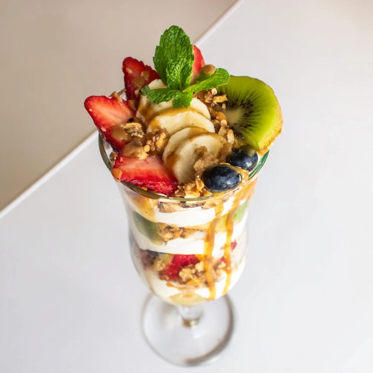 Wholesome yogurt parfait recipe displaying parfait glasses with strawberries, blueberries, banana, and golden honey