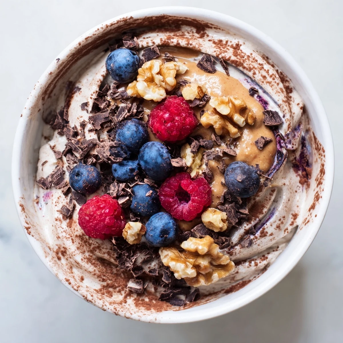 Dairy-free healthy nice cream recipe swirled with peanut butter and coconut flakes for dessert
