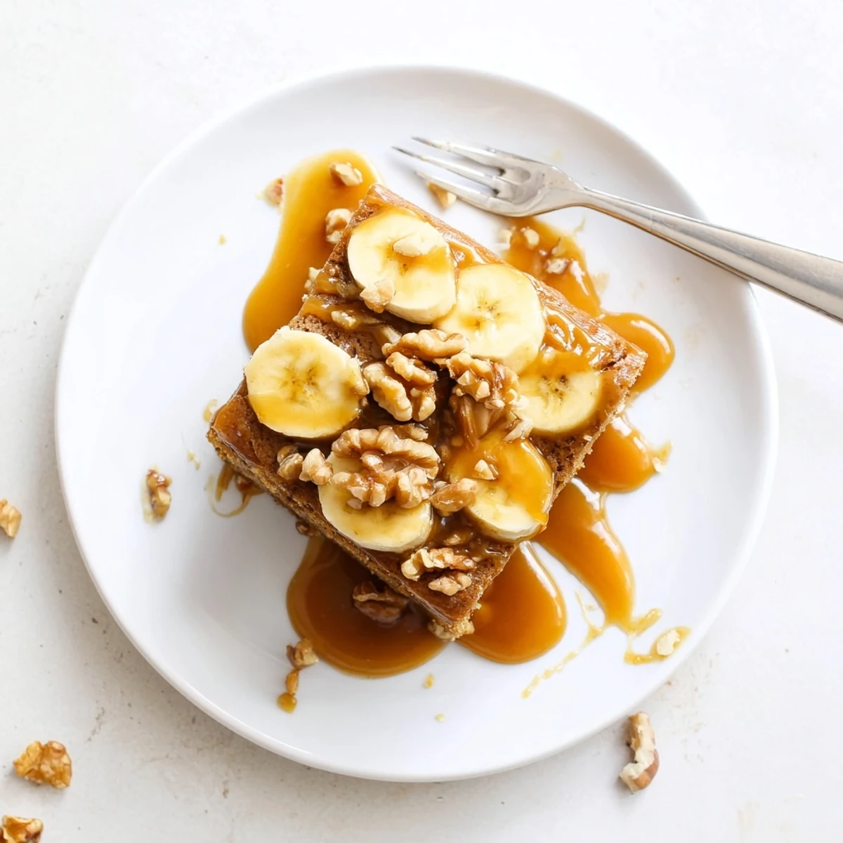 Slice of moist salted caramel brown butter banana cake drizzled with rich caramel and sea salt
