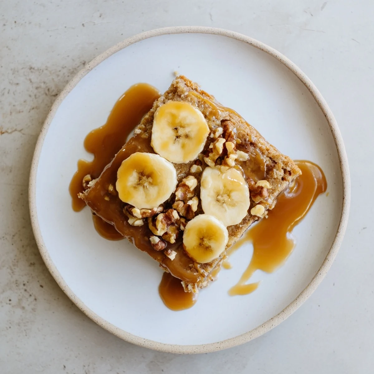 Homemade salted caramel brown butter banana cake with ripe bananas and buttery brown flecks throughout