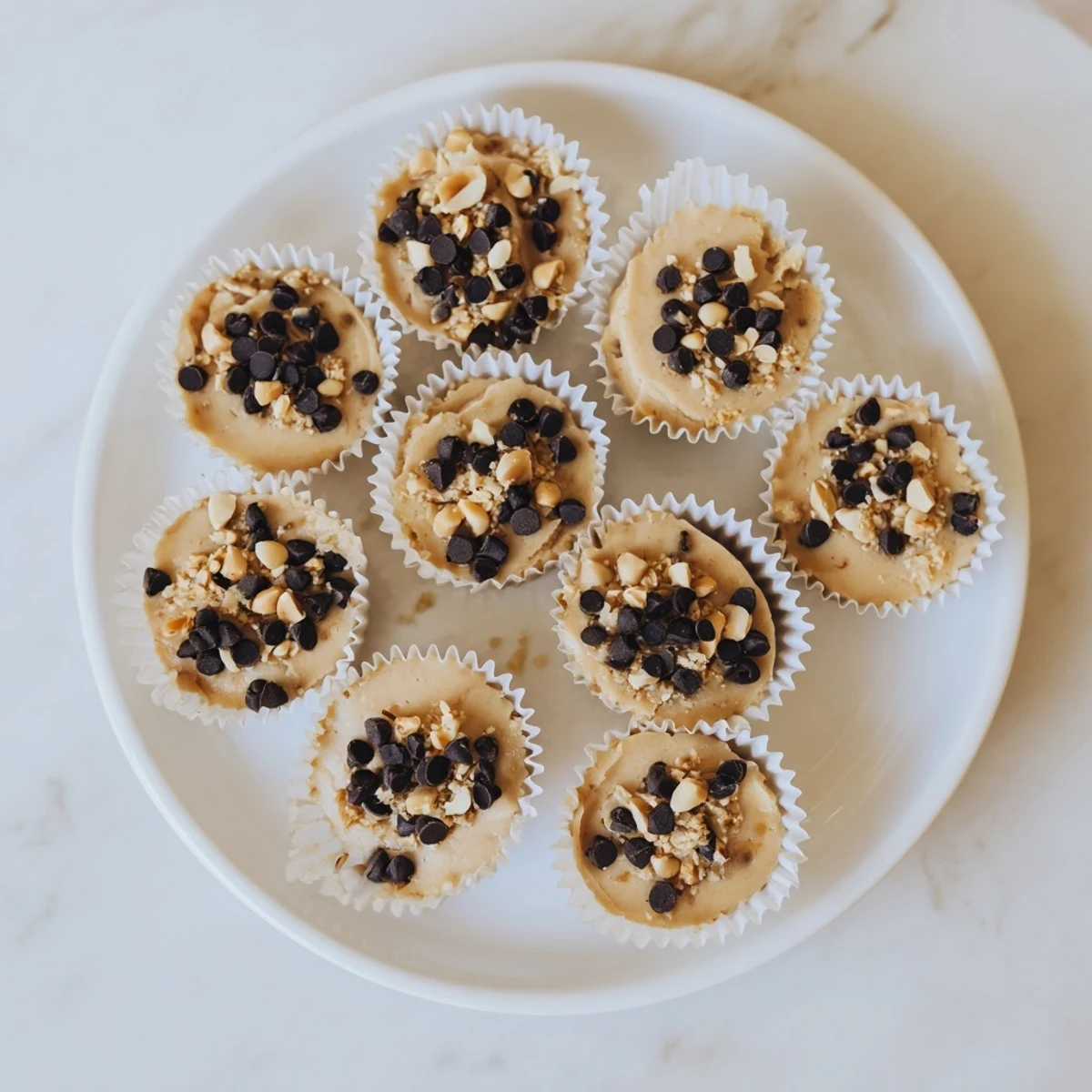 Golden peanut butter Greek yogurt bites with crushed peanut sprinkles arranged on a white serving plate