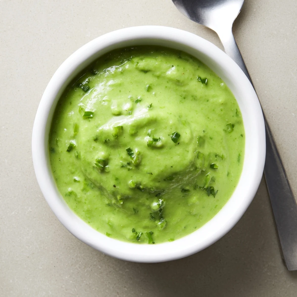 Creamy Peruvian green sauce aji verde drizzled over grilled chicken with fresh cilantro garnish