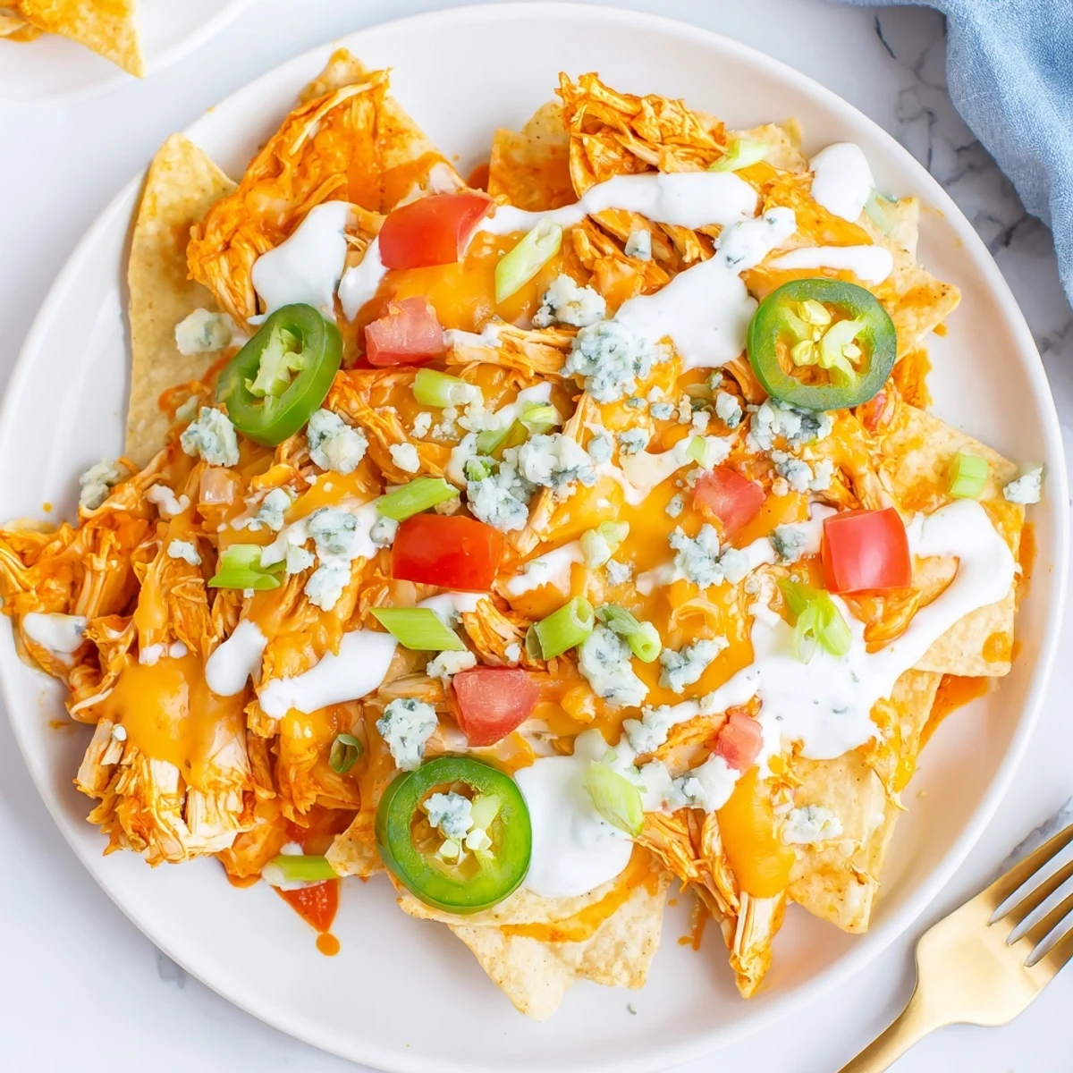 Buffalo Chicken Nachos piled with bubbling cheese, spicy shredded chicken, jalapeño slices