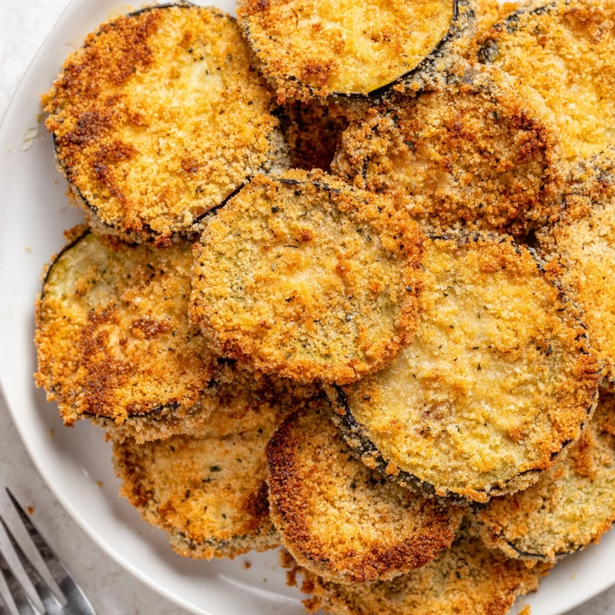 Baking sheet of Crispy Baked Eggplant rounds, Parmesan-crusted and lightly oiled