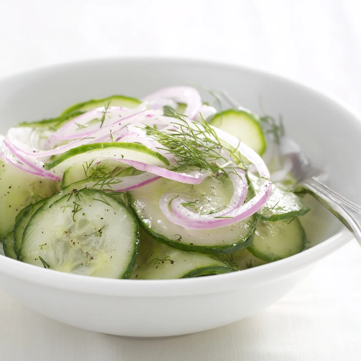 Thinly sliced Cucumber Salad with red onion, bright tangy dressing, summer side