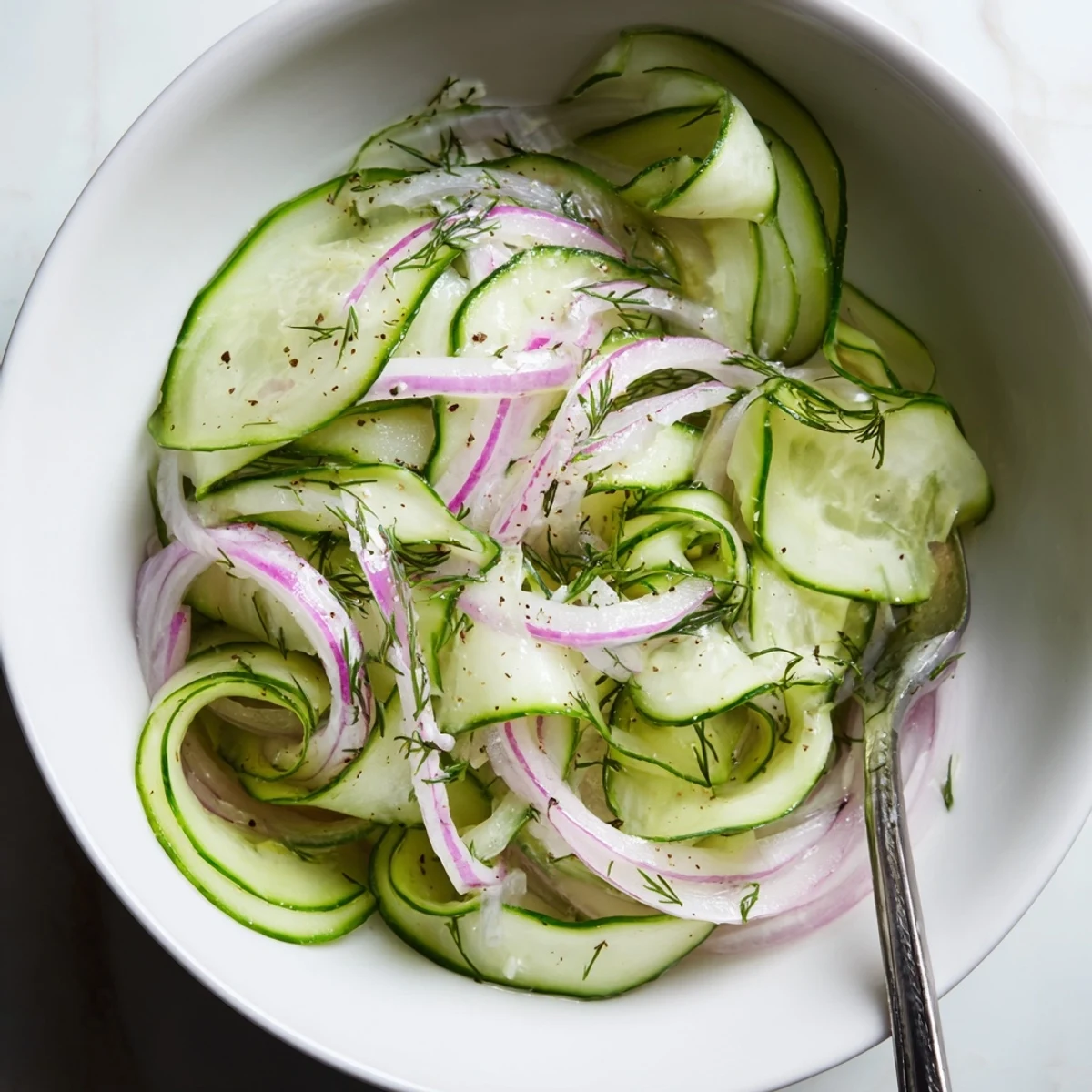 Zesty Cucumber Salad tossed in olive oil and vinegar, pairs with grilled chicken