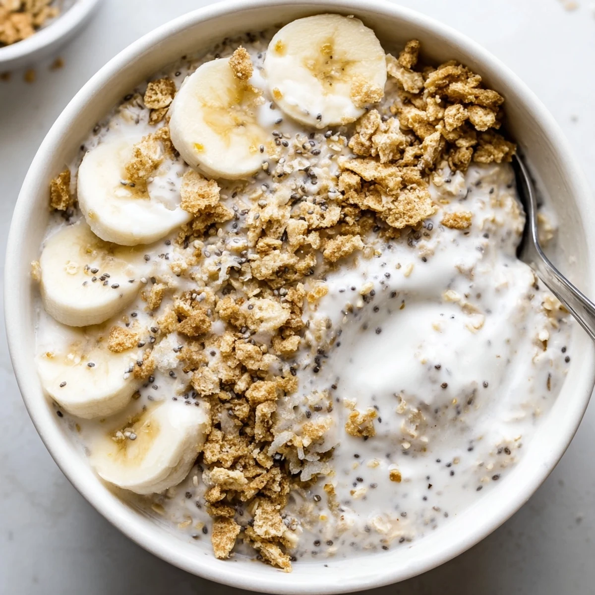 Chilled Coconut Cream Pie Overnight Oats served with spoon, coconut flakes, vanilla aroma.