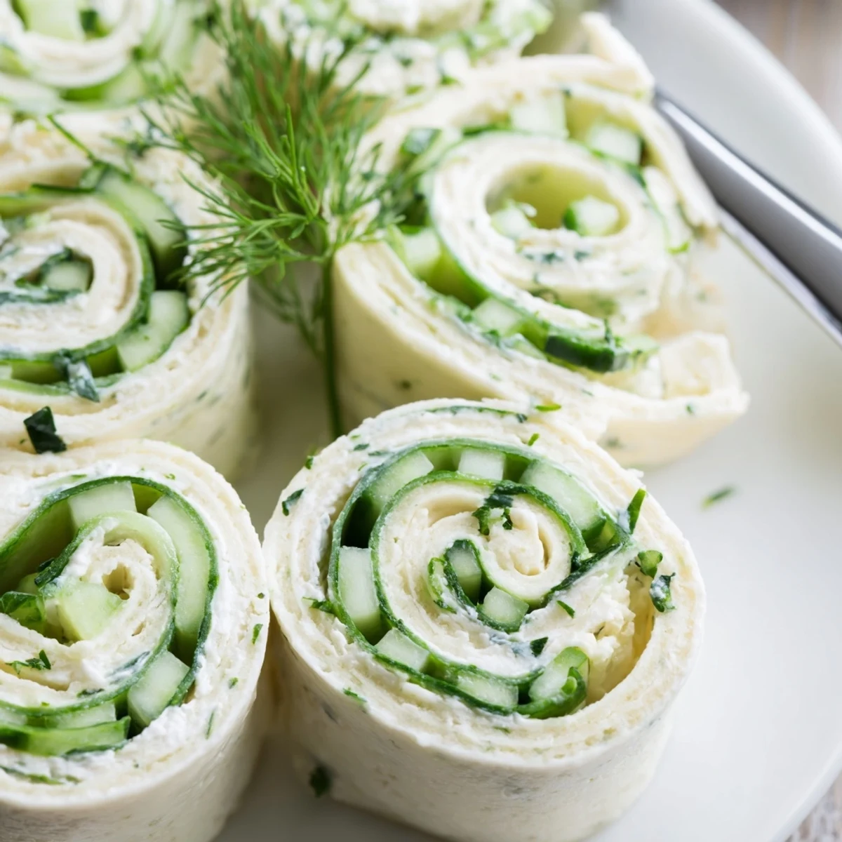 Creamy Cucumber And Dill Pinwheels sliced on cutting board, tortilla swirl.