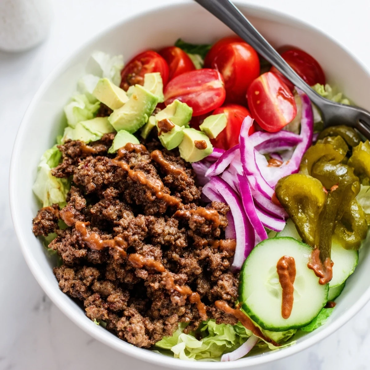 Weeknight Savory Protein Packed Burger Bowls topped with creamy Greek yogurt burger sauce.