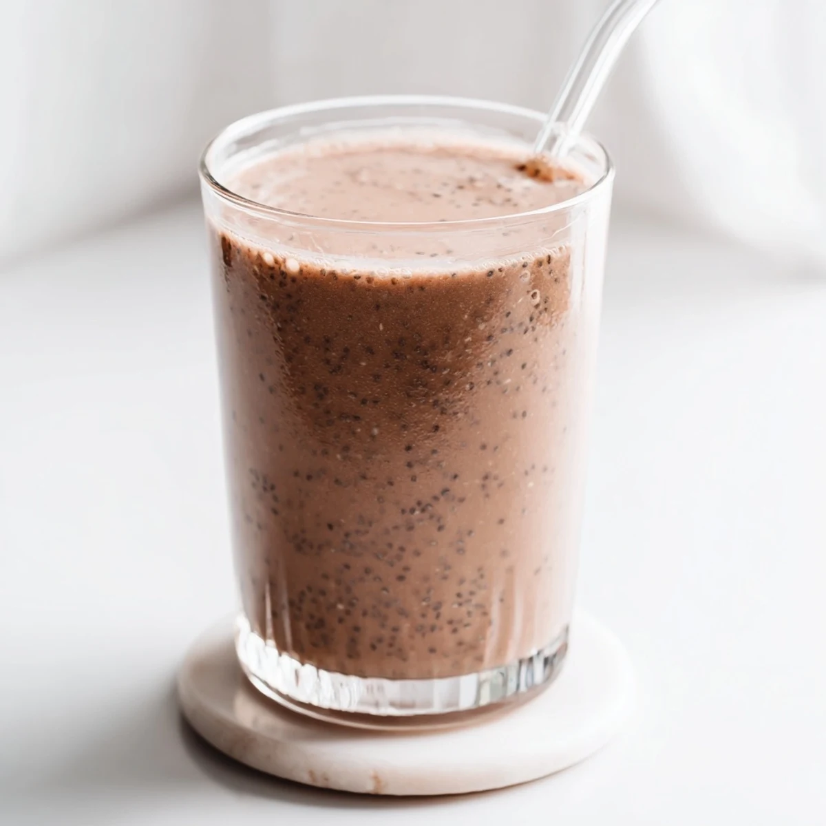 Rich raw chocolate banana shake blending frozen bananas with plant-based milk in a blender