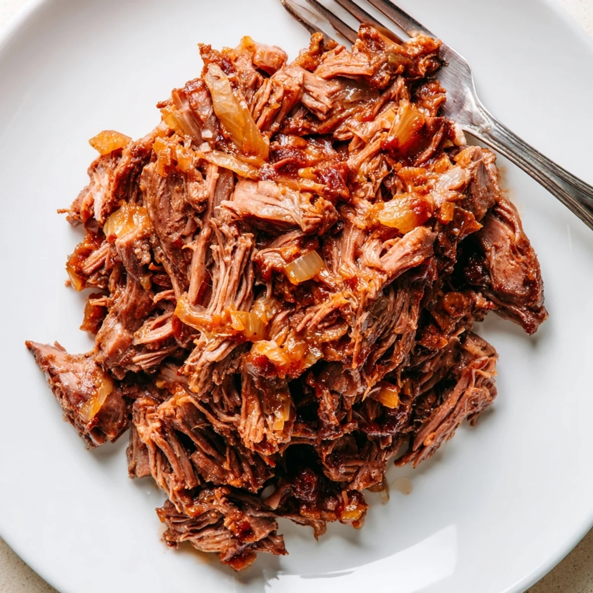 Tender slow cooker beef barbacoa shredded and piled high in a serving bowl