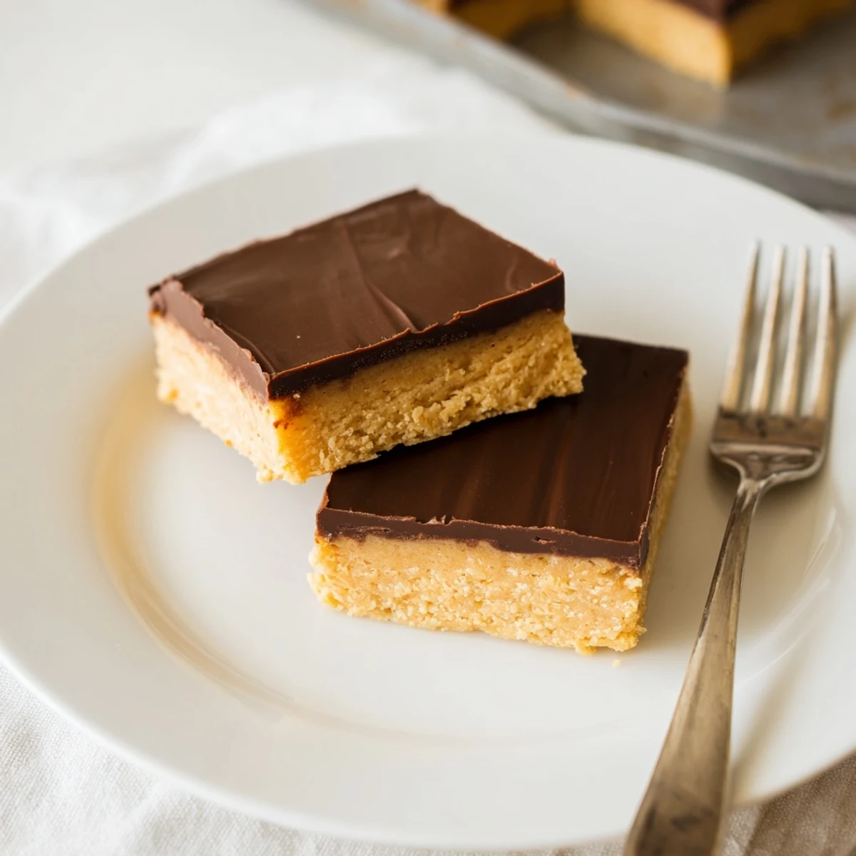 No-bake peanut butter bars featuring creamy peanut butter base topped with melted chocolate