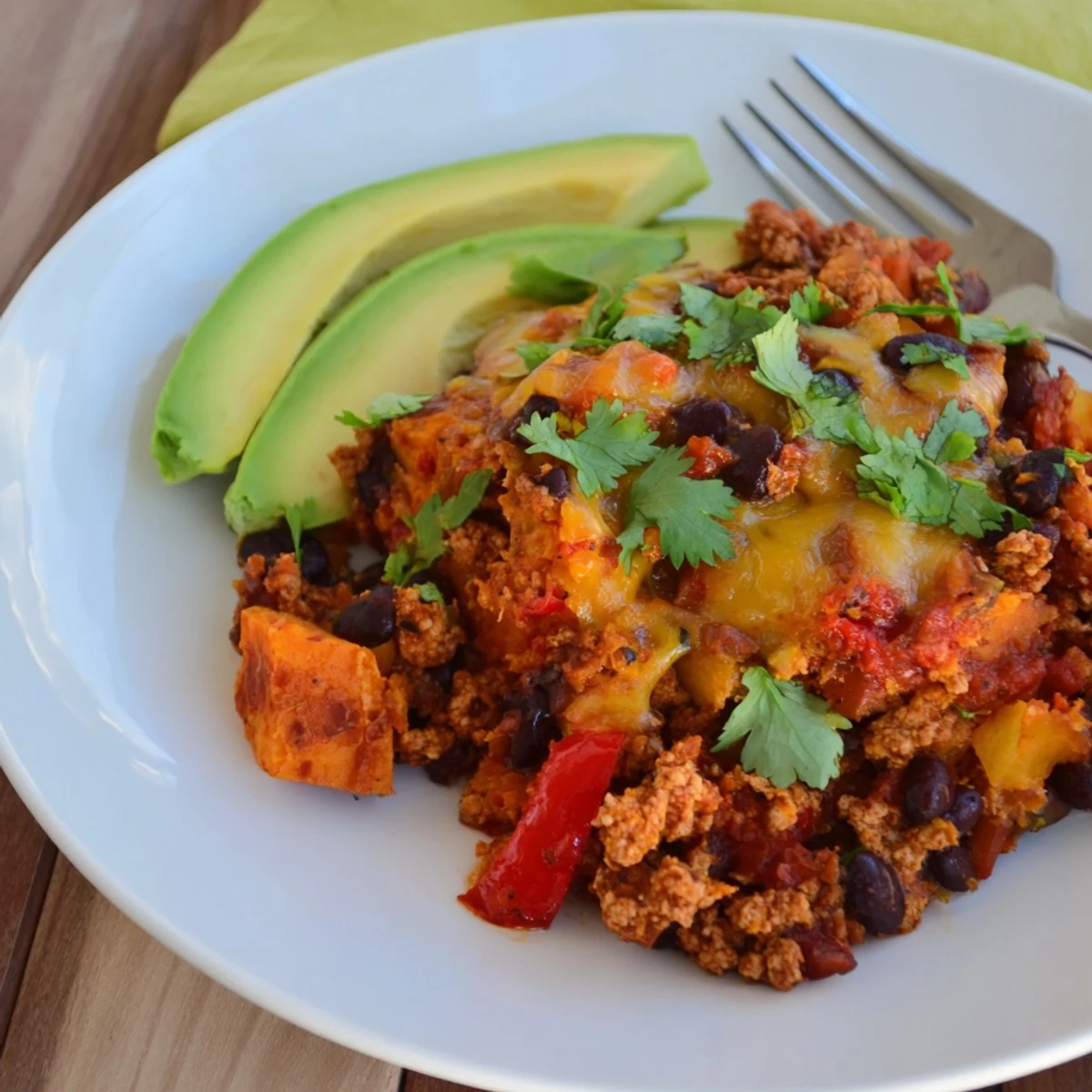 Golden sweet potato turkey black bean bake with melted cheese and fresh cilantro topping