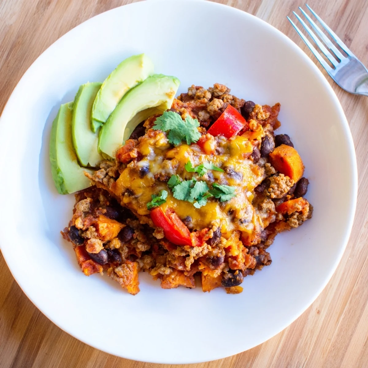 Creamy melted cheddar blankets this hearty sweet potato turkey black bean bake straight from the oven