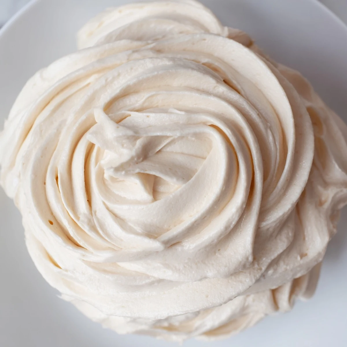 Creamy Italian meringue buttercream swirled onto a freshly baked layer cake