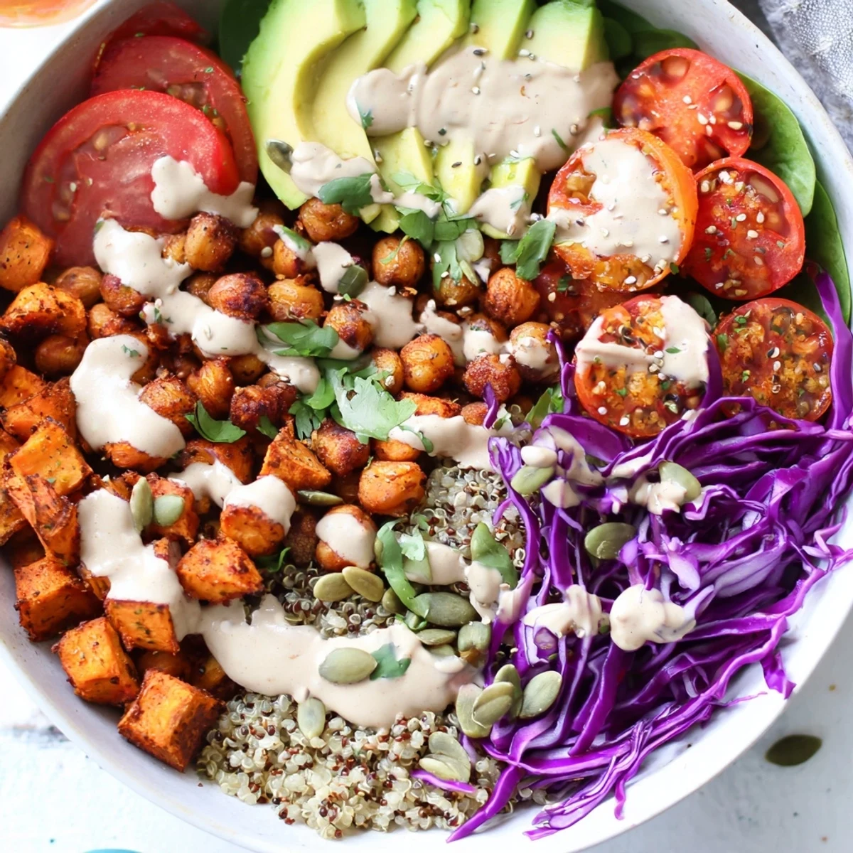 Hearty Buddha Bowl featuring quinoa, spiced chickpeas, fresh vegetables, and drizzled tahini